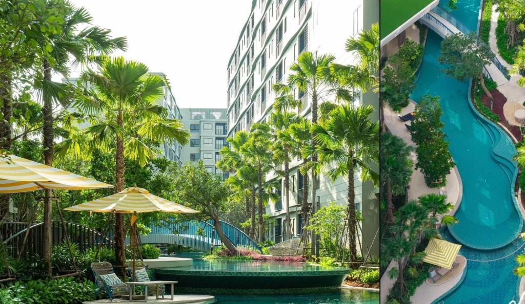 a resort with a swimming pool and palm trees at Dcondo reef 99 in Kathu