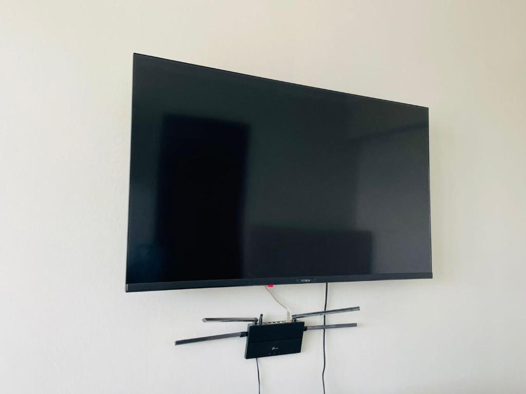 een flatscreen-tv die aan de muur hangt bij Zayana Homes in Meru
