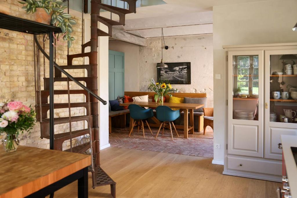 a living room and dining room with a spiral staircase at Idyllic Hideaway In The Countryside in Marienwerder