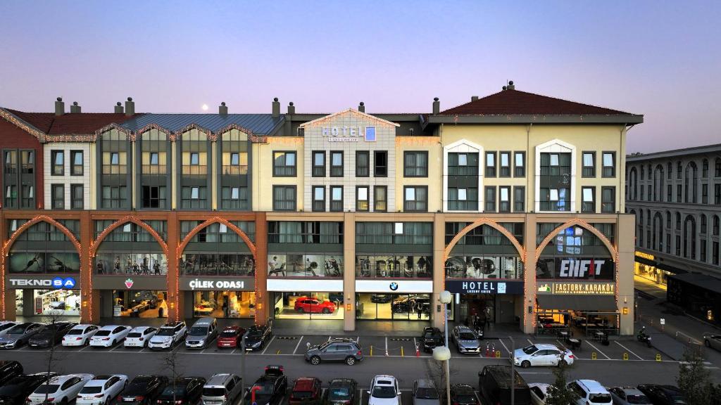 een groot gebouw met auto's geparkeerd op een parkeerplaats bij Hotel54 in Sakarya