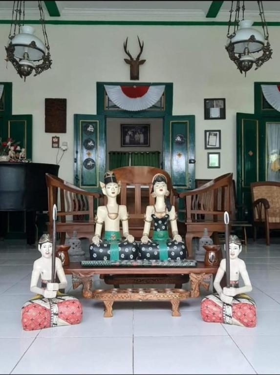 three statues sitting on the floor in a room at Pendopo Andari Homestay in Yogyakarta