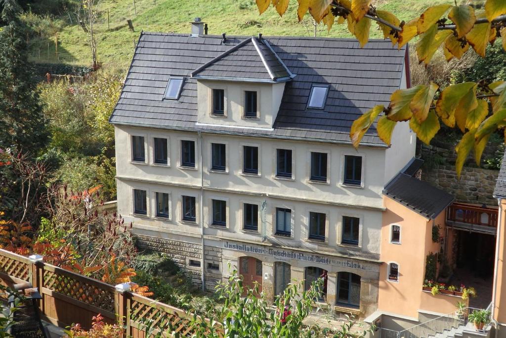 a large white house with a gray roof at Herberge Landstreicher in Königstein an der Elbe
