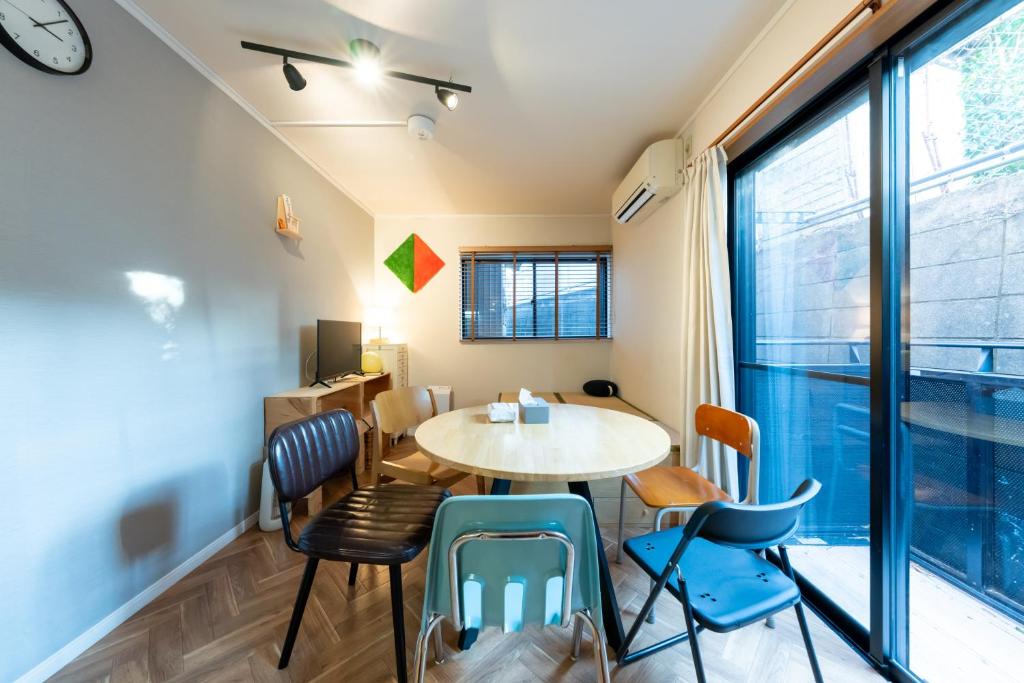 a dining room with a table and chairs and a window at Bushido Kashiwa in Kashiwa