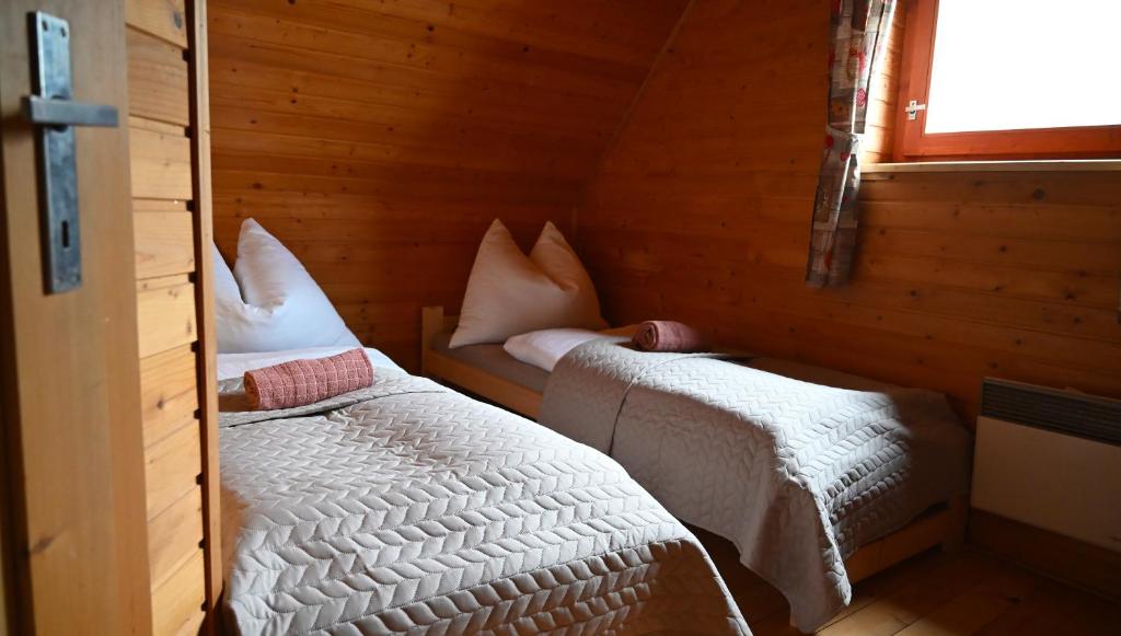 a bedroom with two beds in a wooden cabin at Chata Sauna Sosna in Litmanová