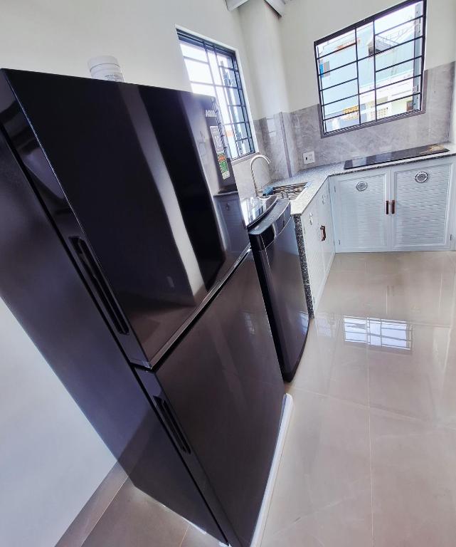a kitchen with a black refrigerator in a room at PHUONG LAN Homestay in Quy Nhon