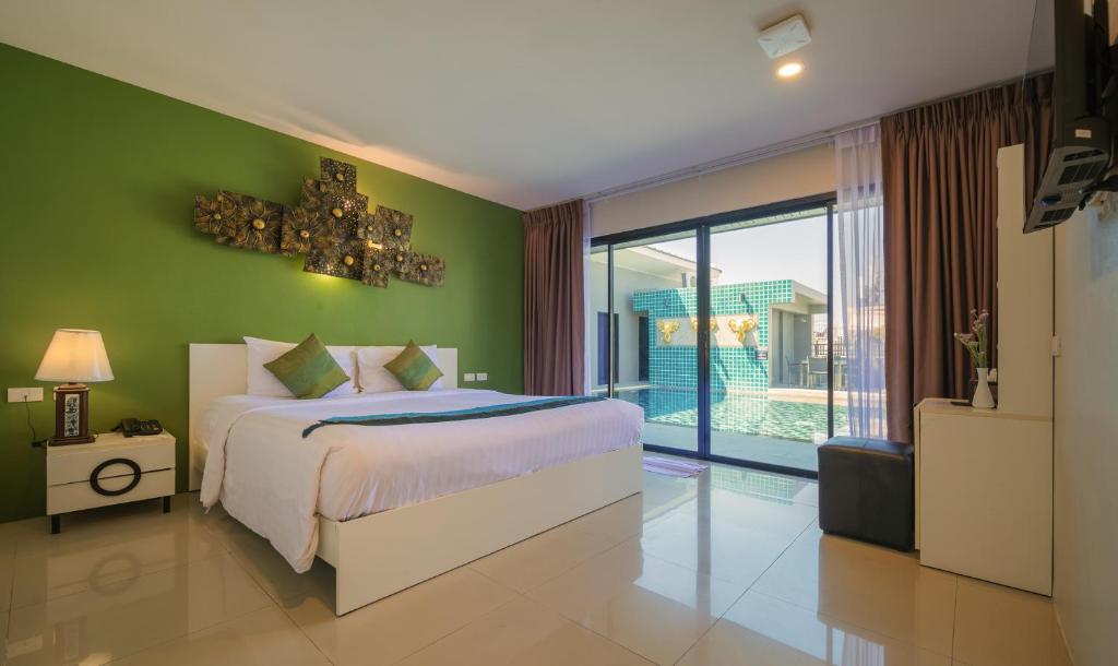 a bedroom with a bed and a green wall at Gu Hotel Patong in Patong Beach