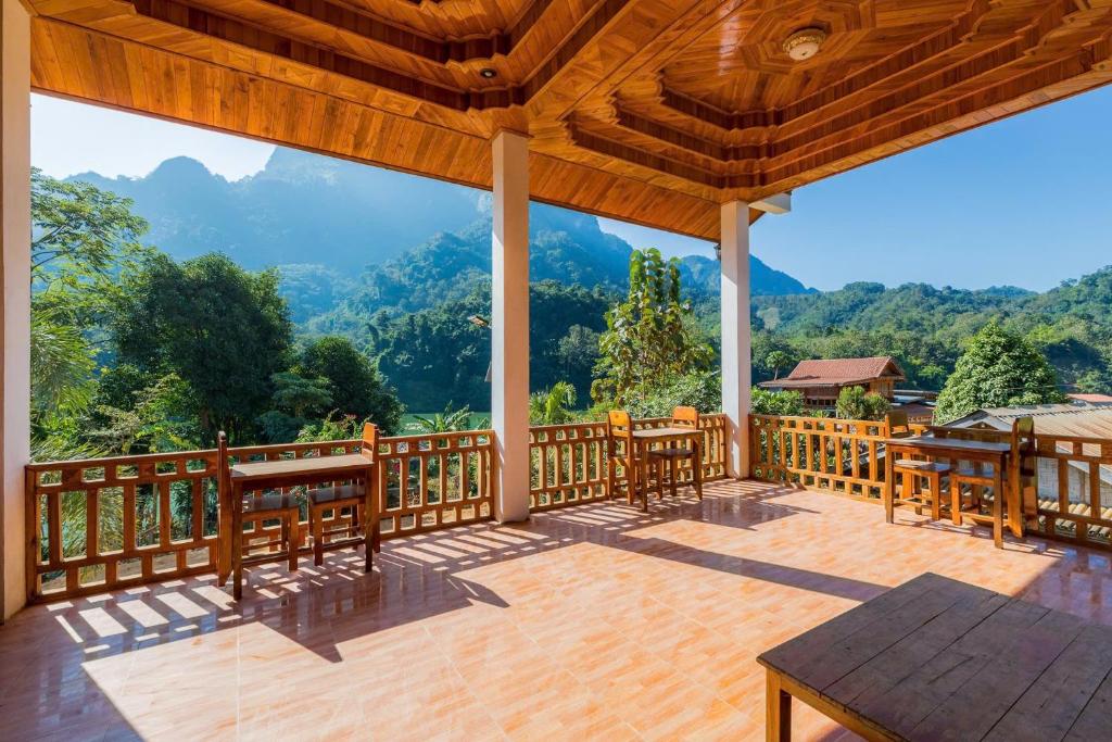 a screened in porch with a view of the mountains at Nongkhiaw IngIng Backpackers Hostel in Nongkhiaw