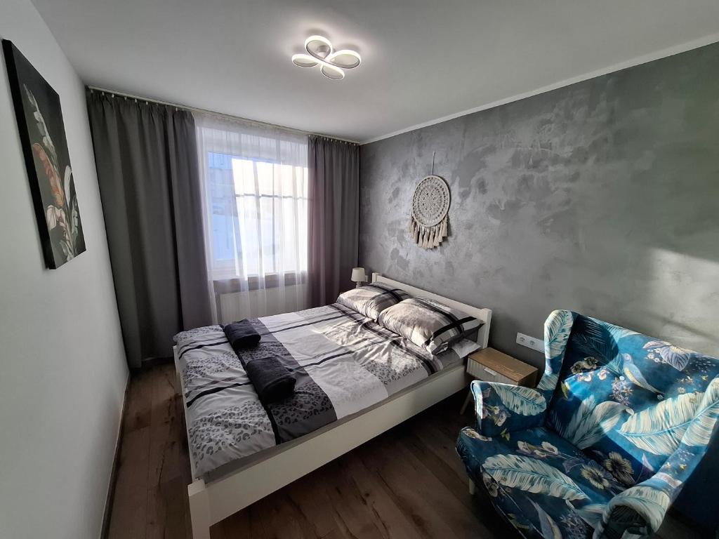 a bedroom with a bed and a chair at Apartament Lewin Kłodzki in Lewin Kłodzki