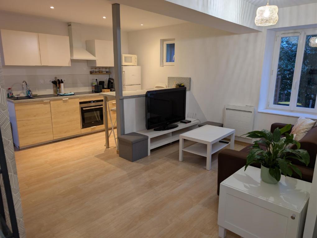 a living room with a television and a kitchen at Gîte Ocrinien Étape vélo face à Gien in Saint-Martin-sur-Ocre