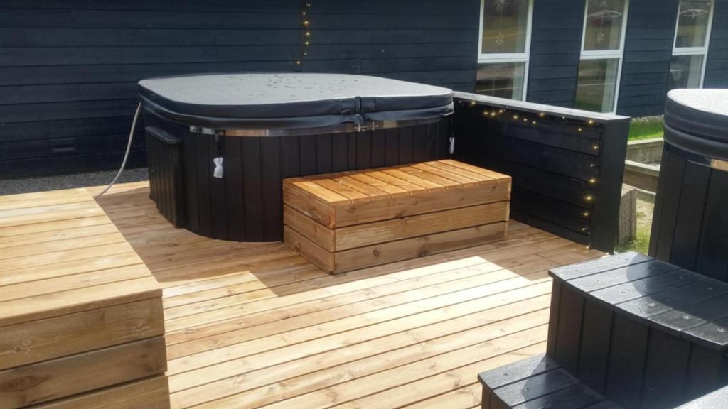 a hot tub sitting on a deck with a wooden floor at Villavilla 637 - Vorupør, Nordjylland in Stenbjerg