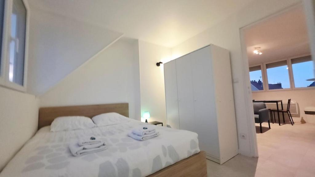 a bedroom with a white bed with towels on it at Studio Foch 4 in Grand-Fort-Philippe