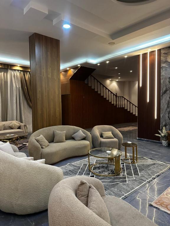 a lobby with couches and a table and a staircase at villa 578 in Sheikh Zayed
