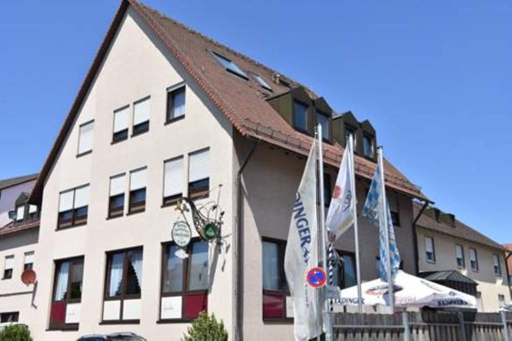 un grand bâtiment blanc avec drapeaux devant lui dans l'établissement Hotel Daucher, à Nuremberg