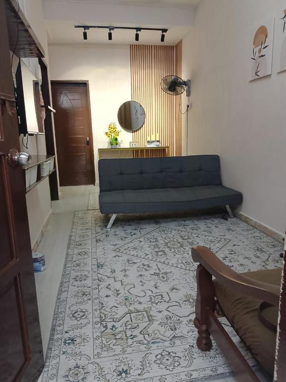a living room with a blue couch and a rug at Tipika Guest House - di Pasir Pekan sempadan 3 Daerah KB, Pasir Mas & Tumpat in Tumpat