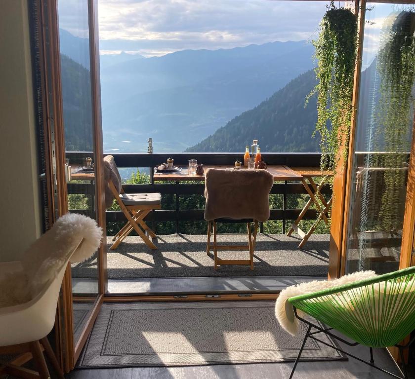 un balcone con tavolo e vista sulla montagna di Le Lézard et la Grenouille BnB a Ovronnaz