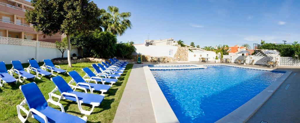 una fila di sedie blu accanto alla piscina di Ona Aldea del Mar a Torrevieja