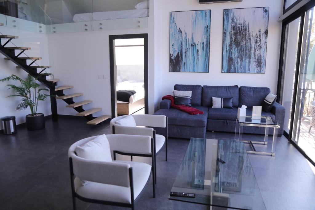 a living room with a blue couch and chairs at Lyv Resort and Venue in Şannīn