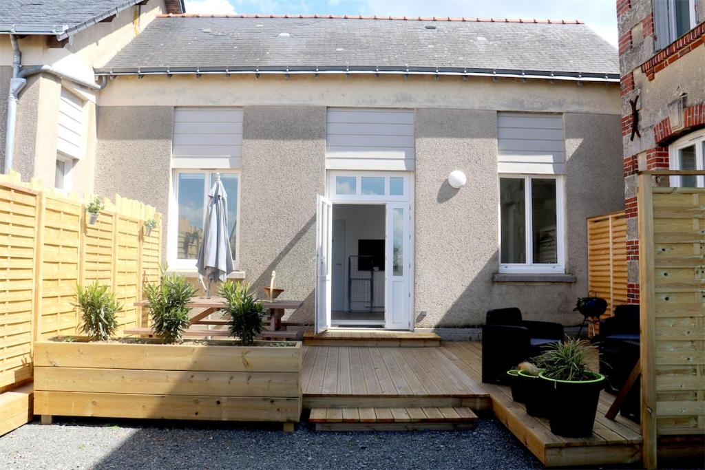 a house with a wooden deck with plants on it at Le Logis d'Anaïs in Trémont