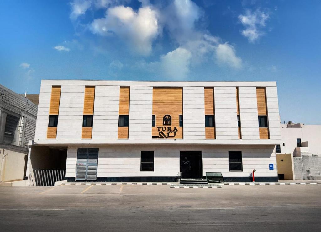 a white building with a sign on the front of it at Tura Residence Al Khaleej- ترى للشقق المخدومة الخليج in Riyadh