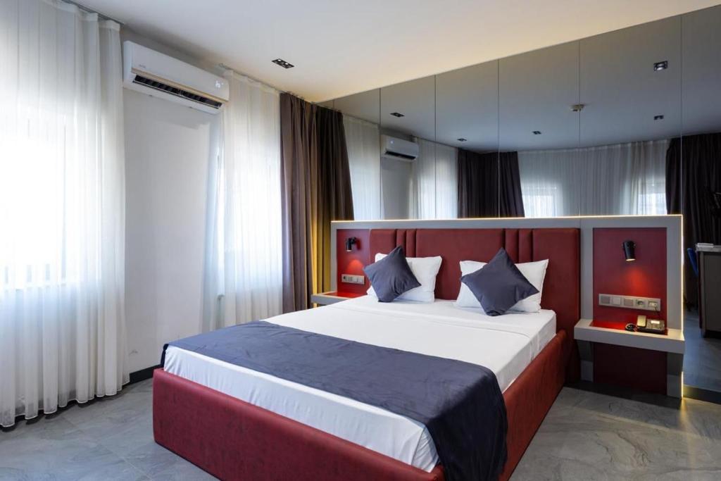 a bedroom with a large bed with a red headboard at Abone Suites in Istanbul