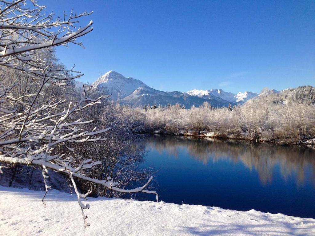 a river in the snow with mountains in the background at Christoph's mountain and lake view in Pflach