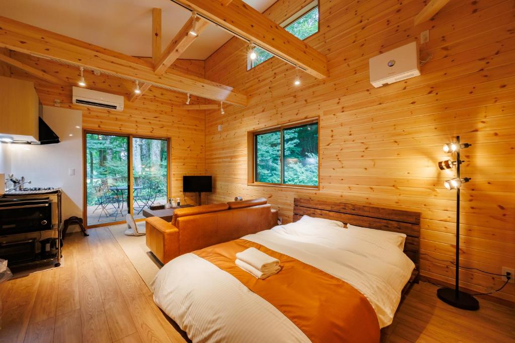 a bedroom with a large bed in a wooden cabin at Narusawa MADOKA in Narusawa