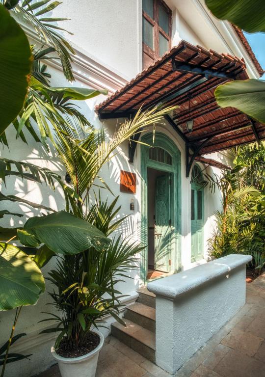 a house with a porch with plants in front of it at LohonoStays Castello Villa 2 in Assagao