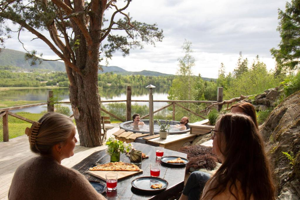 a group of people sitting around a table eating pizza at GapaLux ved Hammervatnet in Levanger