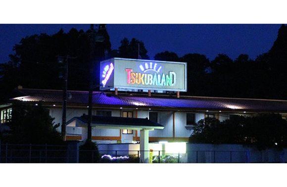 a building with a sign for a restaurant at night at ホテルツクバランド in Tōgane