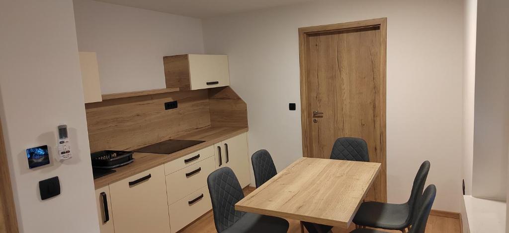 a small kitchen with a wooden table and chairs at MaxLux Apartments in Slovenj Gradec