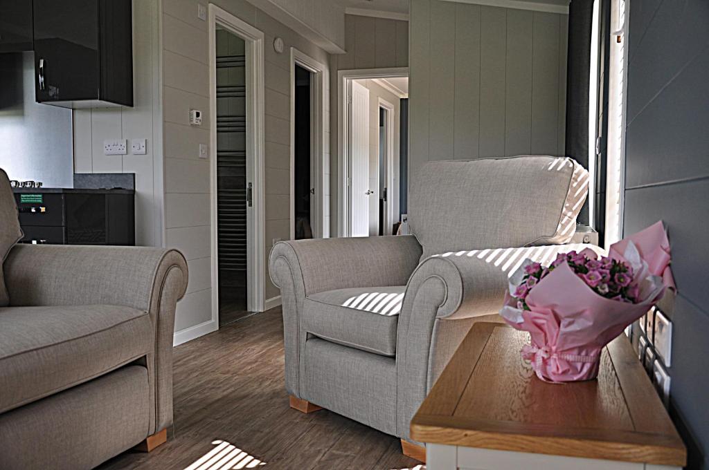 a living room with a chair and a table at Riverside Holiday Park in Amberley