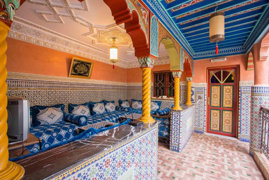 - un salon avec un canapé et une télévision dans l'établissement Ryad Hamza, à Marrakech