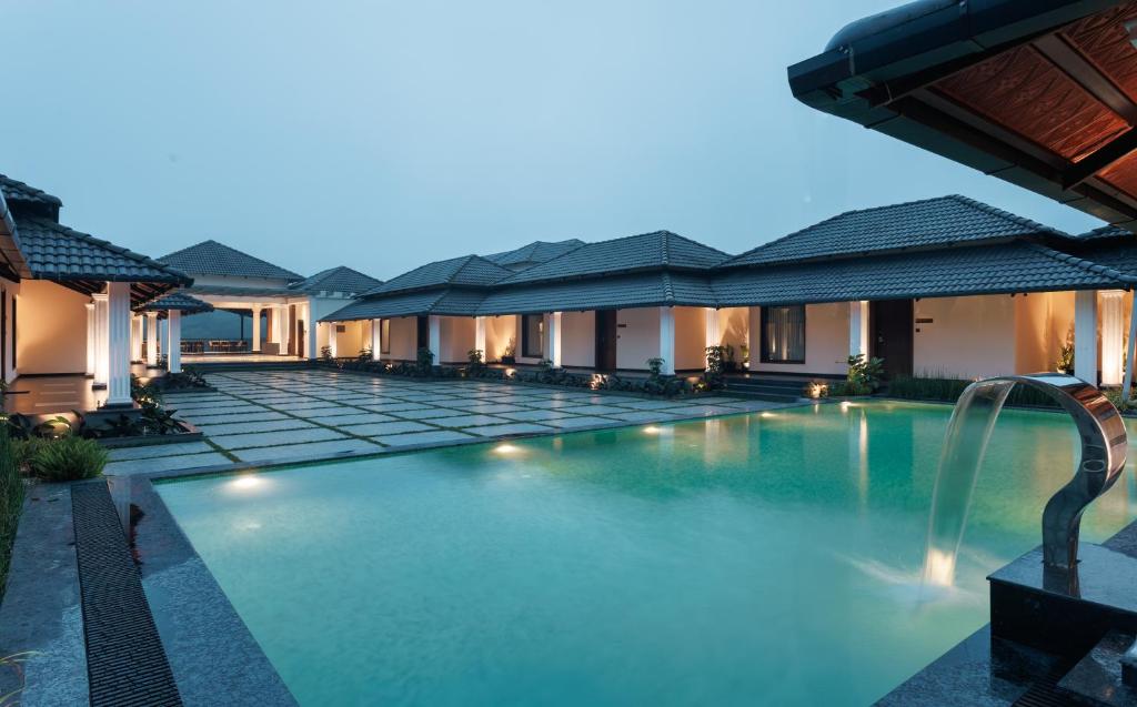 a swimming pool in the middle of a villa at Kohu By Honeyvale in Mudigere