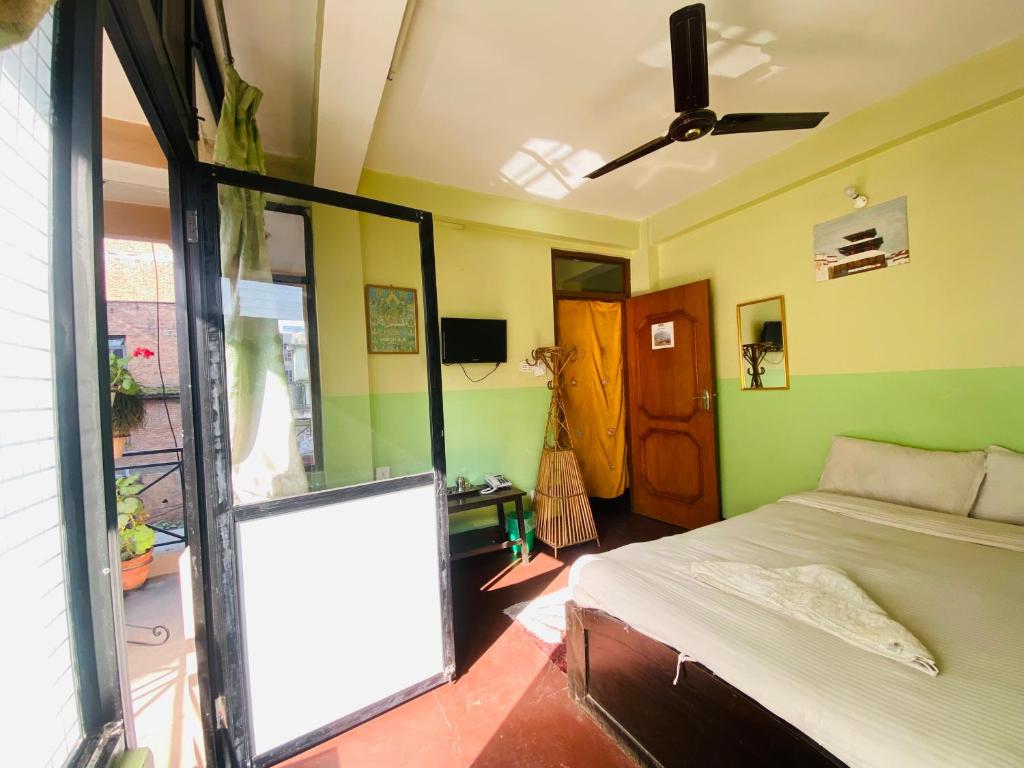 a bedroom with a bed and a large window at Three Peaks Inn in Kathmandu