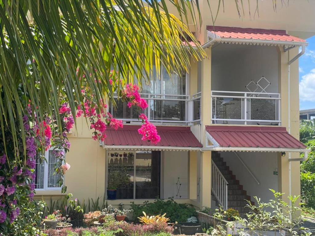 a house with pink flowers on the balcony at Villa Capri first floor in Quatre Bornes