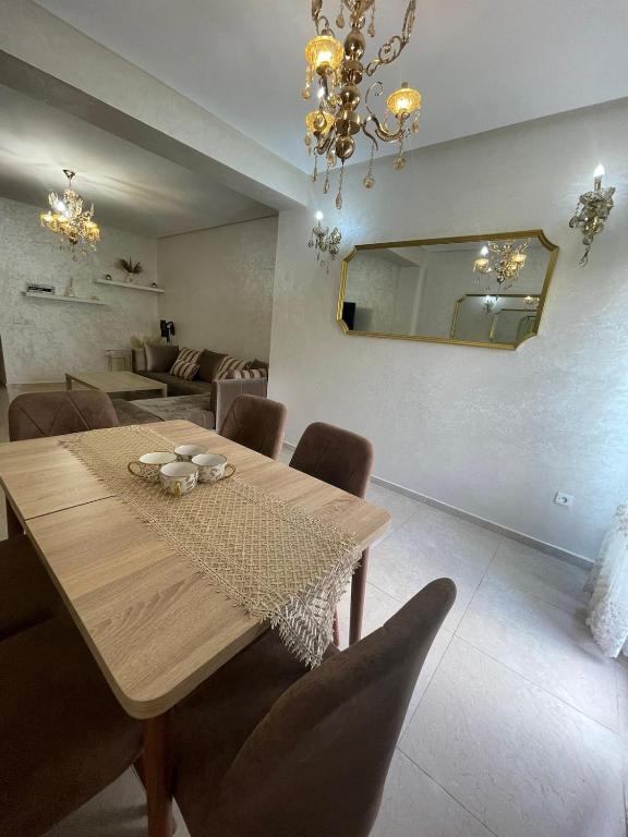 a dining room with a table with chairs and a mirror at ADORA Apartment in Tangier
