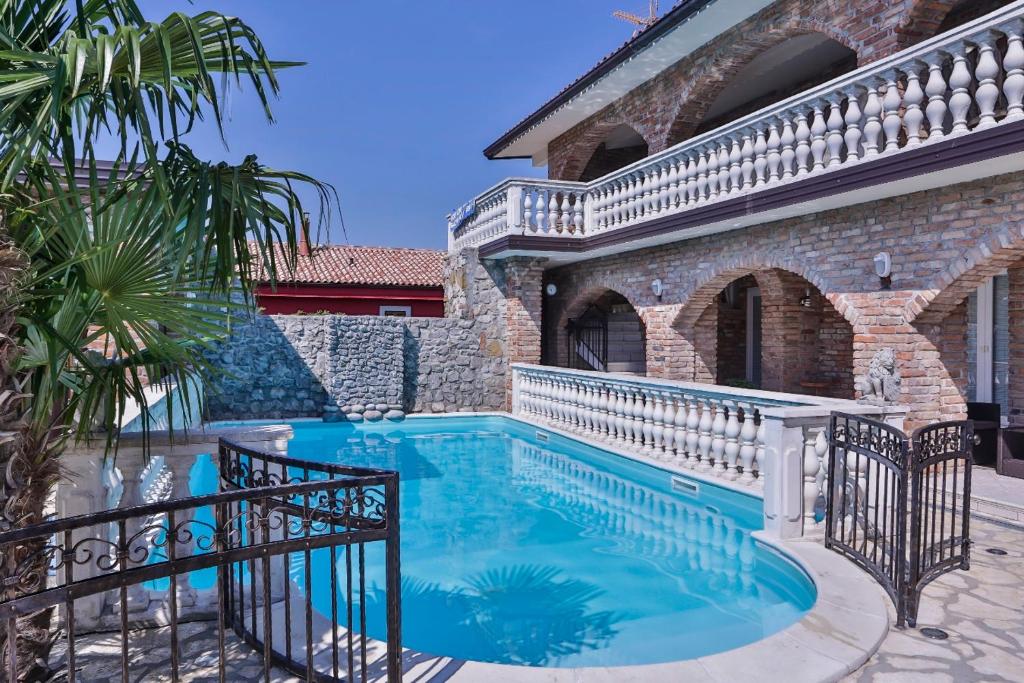 a swimming pool in front of a house at Casa Oasa Boutique rooms Pool near Koper in Koper