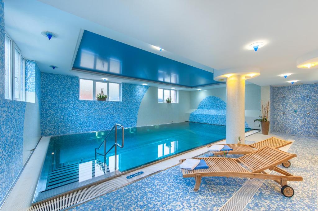una piscina en una casa con paredes azules y una piscina en April hotel Panorama, en Rychnov nad Kněžnou