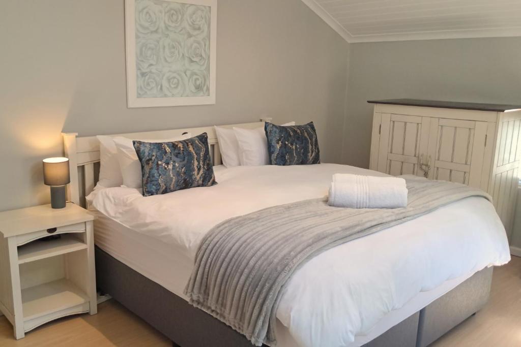 a bedroom with a large bed with white sheets and pillows at 85 The Dunes in Keurboomstrand
