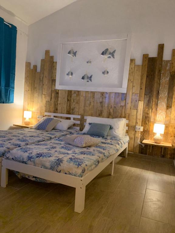 a bedroom with a bed with a wooden wall at Camera La Cinta in San Teodoro