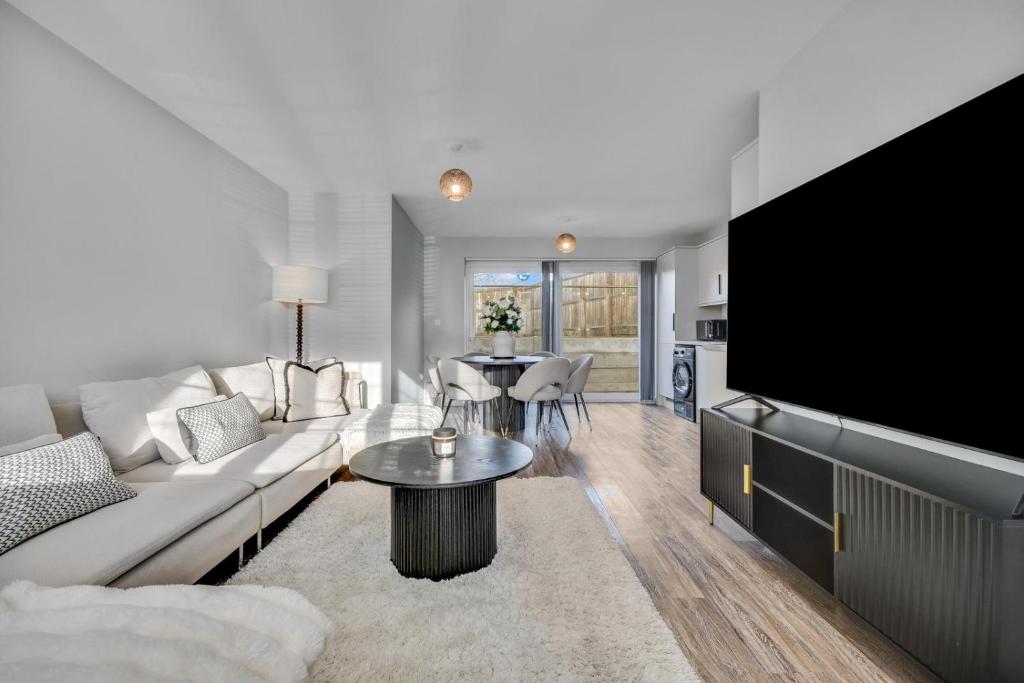 a living room with a couch and a tv at Lovely 2-Bed House with parking in Broomfield