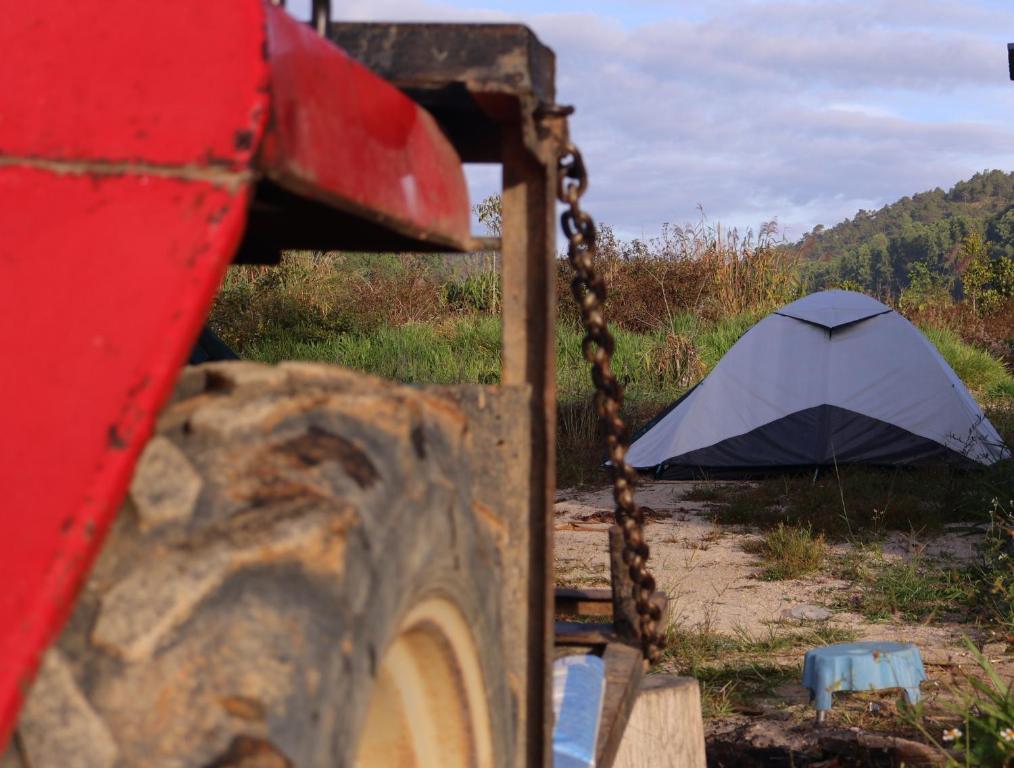a swing with an umbrella in front of a tent at Ditrek Adventure in Ðại Lào