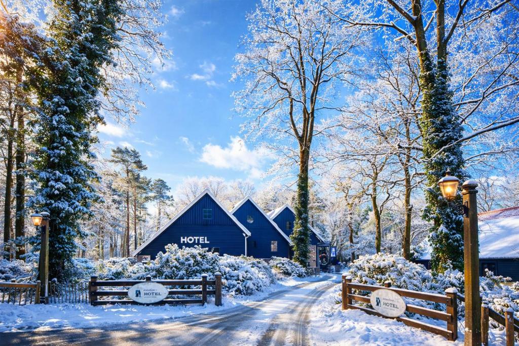 a barn in the snow next to a dirt road at Hotel Erve Hulsbeek in Oldenzaal