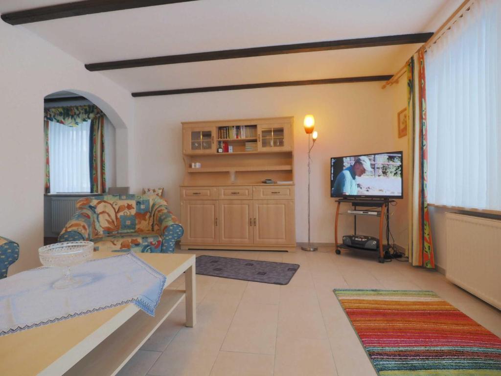 a living room with a couch and a tv at Haus 55 Fewo EG in Arrach
