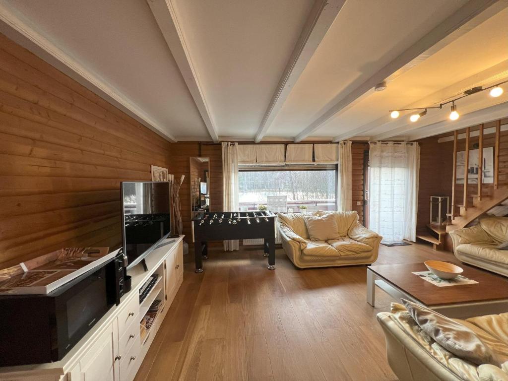a living room with a television and a pool table at Haus 23 Seeblick in Arrach