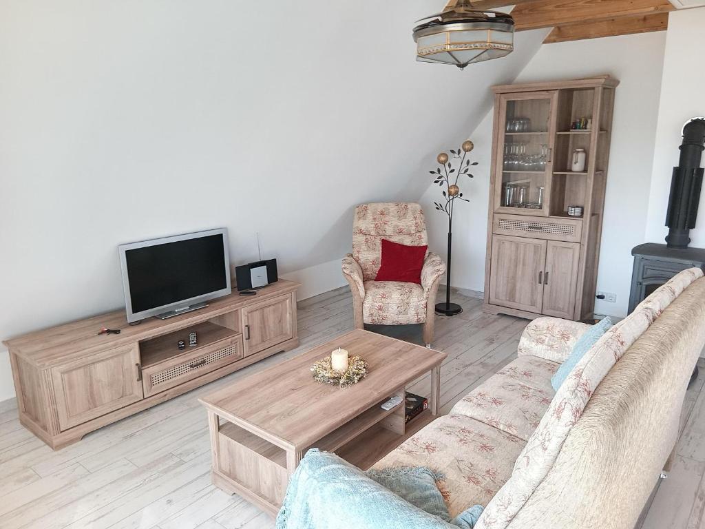 a living room with a tv and two chairs at Fewo Zur Windmühle in Pegau