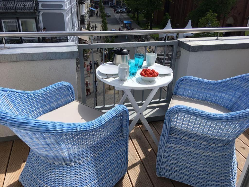 a table and chairs on a balcony with a bowl of fruit at Kirchenplatz 6 Apartment 17 in Warnemünde