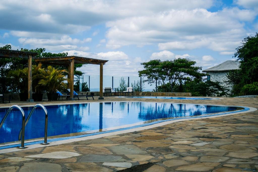 a swimming pool with a gazebo and blue water at Saab Royale Resort in Kajiado