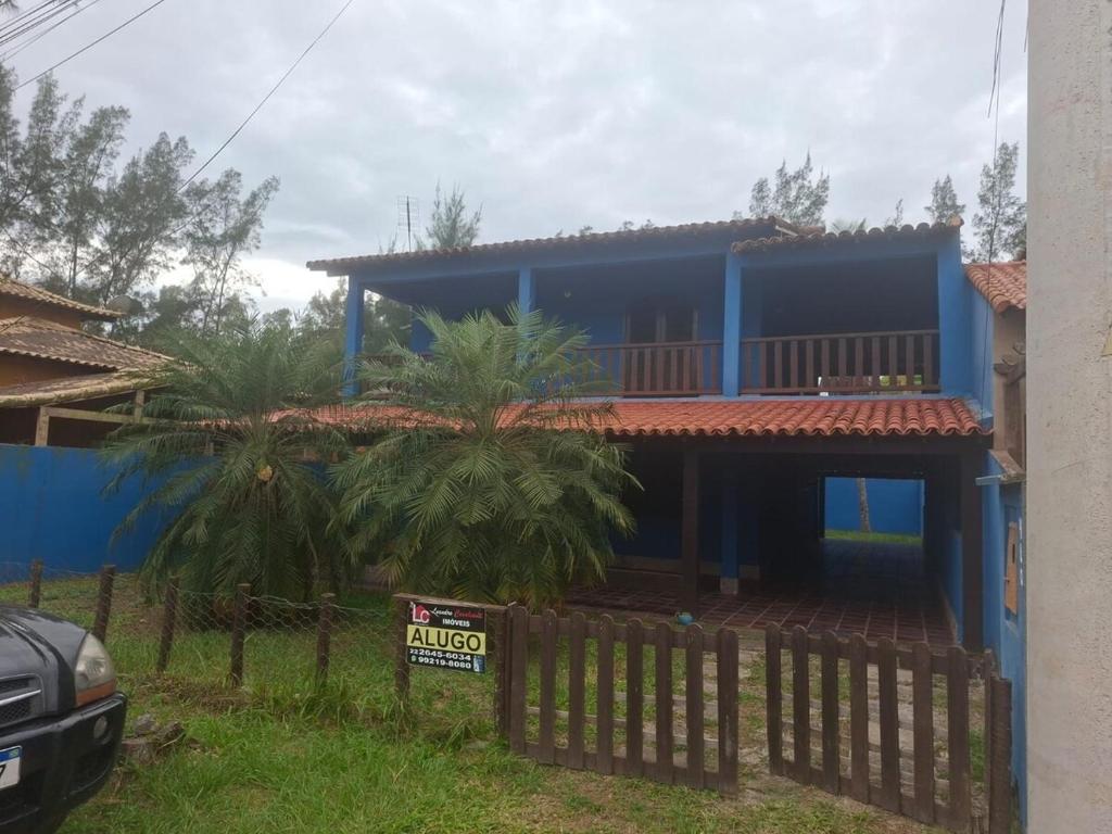 a blue house with a fence in front of it at Casa Espaçosa em Unamar in Cabo Frio