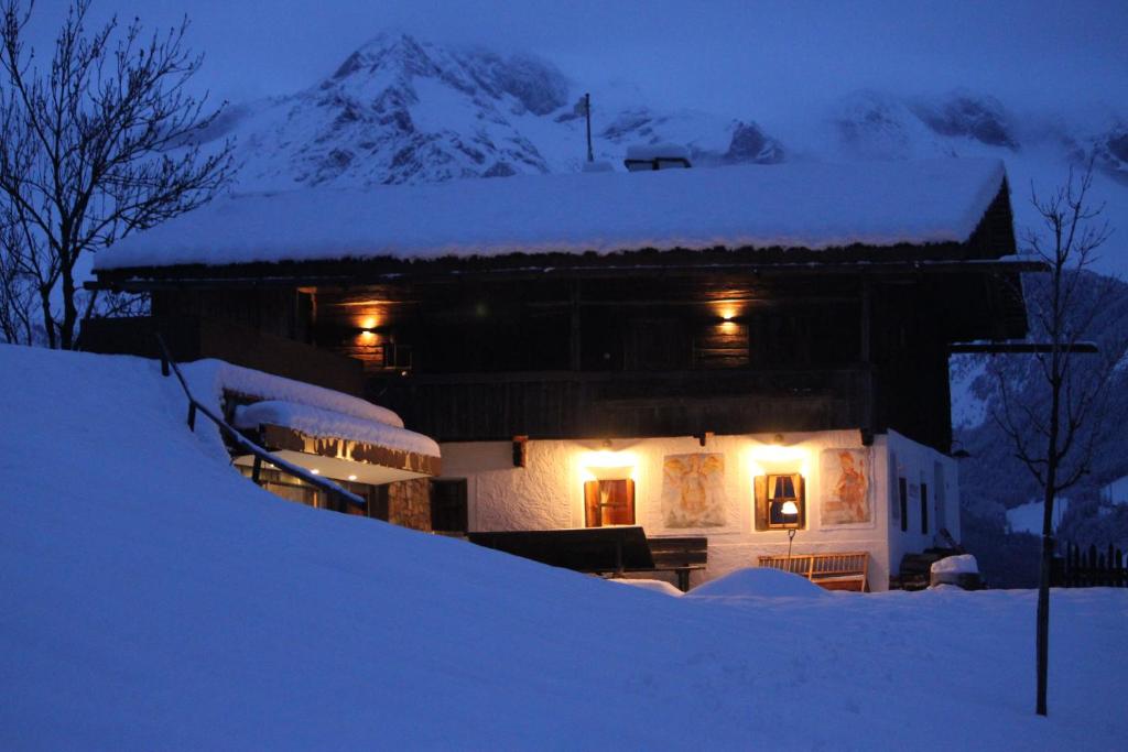 una casa cubierta de nieve por la noche con una montaña en Mountain Chalet Obertreyen, en Campo Tures